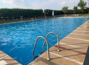 una piscina con agua azul y barandillas metálicas en Casa Rural la Ribera, en Cabezuela