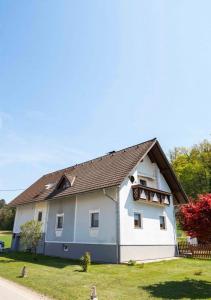 duży biały dom z brązowym dachem w obiekcie Helgas Ferienwohnung w mieście Gleinstätten