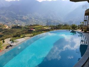 a large swimming pool with a view of a mountain at Sapa Clay House - Mountain Retreat in Sapa