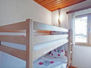 ein Etagenbett aus Holz in einem Zimmer mit Fenster in der Unterkunft Chalet Monika in Sankt Koloman