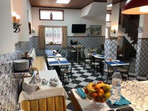 a restaurant with a table with a bowl of fruit on it at Residencial Celeste in Águeda