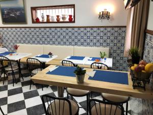 a restaurant with tables, chairs, and tables in it at Residencial Celeste in Águeda