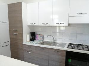 een keuken met witte kasten en een wastafel bij Apartment Jelena in Podstrana