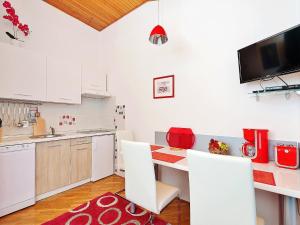eine Küche mit weißen Schränken sowie einem Tisch und Stühlen in der Unterkunft Apartments Brioni Colors in Pula