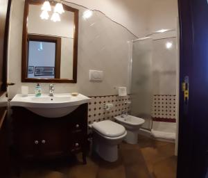 ein Badezimmer mit einem Waschbecken, einem WC und einem Spiegel in der Unterkunft B&B Corte Barocca in Lecce