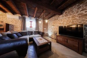 Una sala de estar con un sofá y un televisor de pantalla plana. en Holiday home Mare, en Petrčane