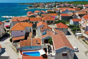 Una vista aérea de un pueblo con casas y el océano. en Holiday home Mare, en Petrčane