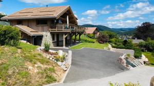 a house with a driveway in front of it at Chalet Horizon 180 4 étoiles Sauna in Gérardmer