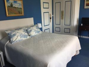 um quarto com uma cama com uma parede azul em Château de Colombier em Saint-Julien
