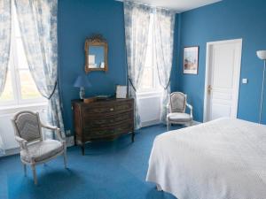 Saint-JulienにあるChâteau de Colombierの青いベッドルーム(ベッド1台、椅子2脚付)