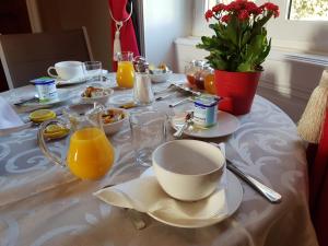 a table topped with plates of food and orange juice at Château de Colombier in Saint-Julien