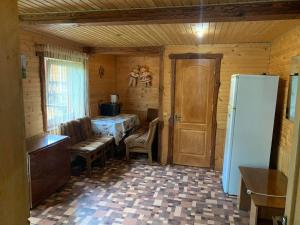 - une cuisine avec un réfrigérateur et une table dans la chambre dans l'établissement садиба Сніжок, à Yaremtche 5 autres photos