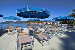 a group of chairs and umbrellas on a deck at Hotel San Terenzo in Lerici