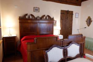 Un dormitorio con una gran cama de madera con sábanas rojas. en Alla Locanda Del Cinquecento en Castrocaro Terme