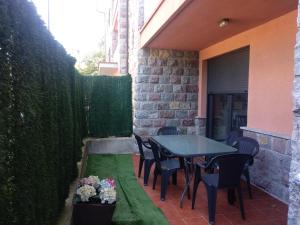 un patio con mesa, sillas y una valla en Sumiciu, apartamento con piscina en Llanes, en Llanes