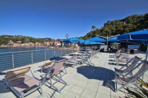 a row of chairs and blue umbrellas on a boat at Hotel San Terenzo in Lerici
