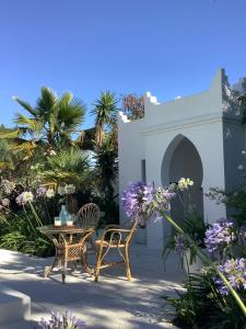 チクラナ・デ・ラ・フロンテーラにあるKasbah Andaluz guest houseの花が咲くパティオ(テーブル、椅子付)
