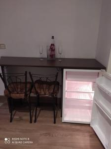 a black table with two wine glasses and a refrigerator at Suite Love Jacuzzi (Casas Toya) in Uceda