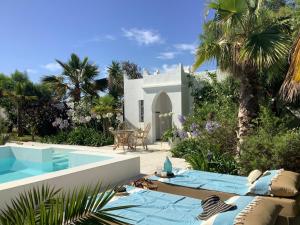 een villa met een zwembad naast een resort bij Kasbah Andaluz guest house in Chiclana de la Frontera