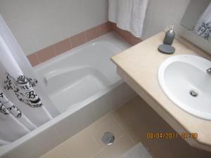 a bathroom with a white tub and a sink at Penthouse Marina Sol in Madalena do Mar +31 photos