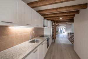 una cucina con mobili bianchi e un lavello di Duplex Allegro a La Neuveville