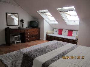 a bedroom with a bed and a couch and skylights at Penthouse Marina Sol in Madalena do Mar