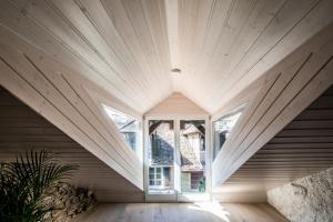 una camera mansardata con una grande finestra in una casa di Duplex Allegro a La Neuveville