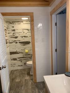 a bathroom with a toilet and a wooden wall at Deer Run on the Atlantic in Big Pine Key