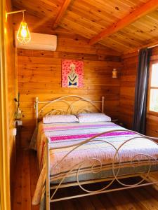 a bedroom with a bed in a log cabin at Happy Glamping Cy in Ayios Theodhoros