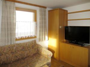 a living room with a couch and a flat screen tv at Holiday Home Wallner - FUC110 by Interhome in Fusch an der Glocknerstraße