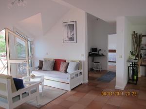 a living room with a white couch and chairs at Penthouse Marina Sol in Madalena do Mar