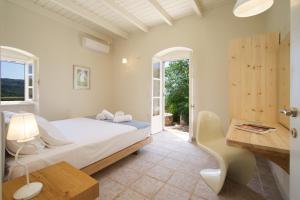 a bedroom with a bed and a desk and windows at Stone Cottages in Khalikerí +59 photos