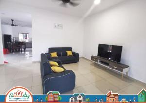 sala de estar con sofá y TV en PD Homestay Famille (near beach) en Port Dickson