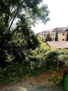 uma vista para um campo com árvores e edifícios em Pension Villa ** em Comillas
