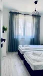 a bedroom with two beds and a window at Legnica Apartament 53m2 Delux 6 in Legnica +5 photos