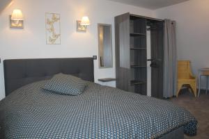 um quarto com uma cama com um edredão azul e branco em Gîte Le Cep d'Or Alsace em Saint-Hippolyte