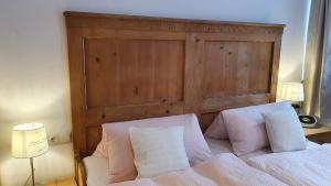 a bed with two white pillows and a wooden headboard at Gästezimmer Vogtareuth Rinser in Vogtareuth