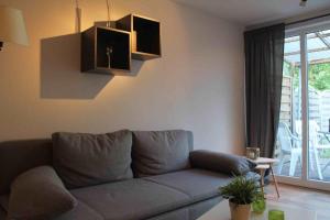 a living room with a gray couch and a window at Ferienwohnung Roggenbach in Büdelsdorf