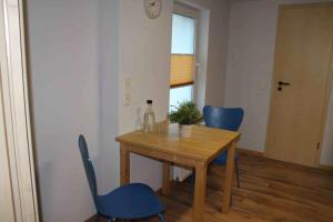 a dining room with a table and blue chairs at Ferienwohnung Roggenbach in Büdelsdorf