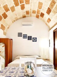 a bedroom with a bed and a table with a vase on it at Dimora dei Pellegrini 8 in Polignano a Mare