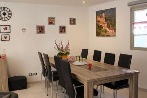 Gîte Le Cep d'Or Alsace في سانت هيبوليت: غرفة طعام مع طاولة وكراسي خشبية