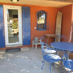 une table et des chaises bleues devant un bâtiment dans l'établissement Ocra Pure, à Roussillon