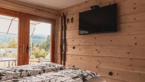 a bedroom with two beds and a television on a wall at Vintgar studio in Bled