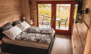 a room with a bed and a balcony with a table at Vintgar studio in Bled