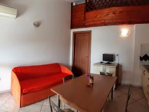 a living room with a red couch and a table at Appartamenti Marina Maria in Murta Maria