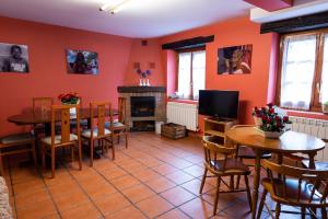 comedor con paredes de color naranja, mesa y sillas en Casa Rural Areano, en Escoriaza