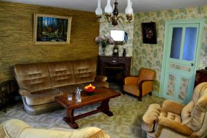 uma sala de estar com mobiliário de couro e uma mesa em Gite Le Masgiral em Saint-Christophe