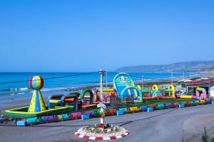 a colorful playground on the beach with the ocean in the background at Maison 3 chambres Imi ouaddar in Imi Ouaddar