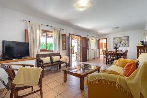 a living room with a couch and a tv at Casa Es Pins in Santa Eularia des Riu