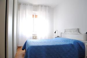 Un dormitorio con una cama azul y una ventana en Gaiavacanze Beach Apartment, en Bordighera